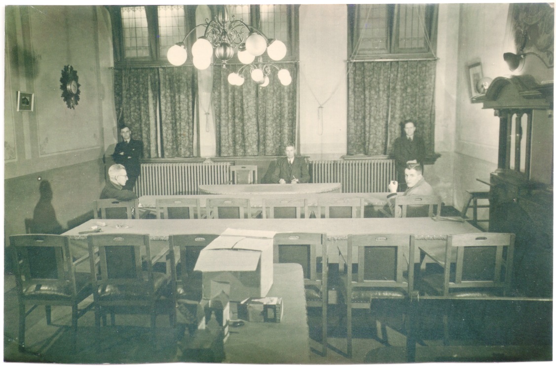 Foto van het interieur van het Distributiekantoor Markelo. Johannes Prins (1915-1976) zit rechts.